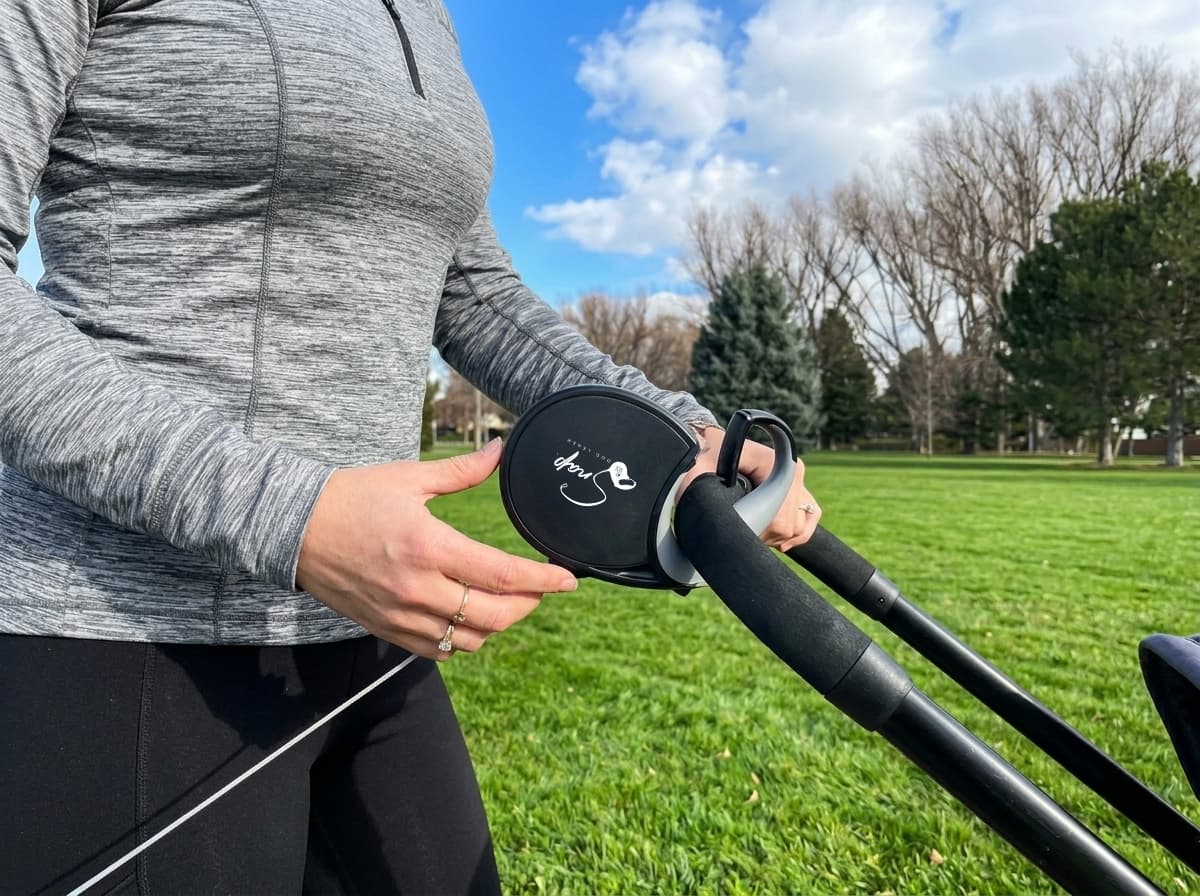 Retractable dog leash with clip connected to a stroller frame for hands-free walking
