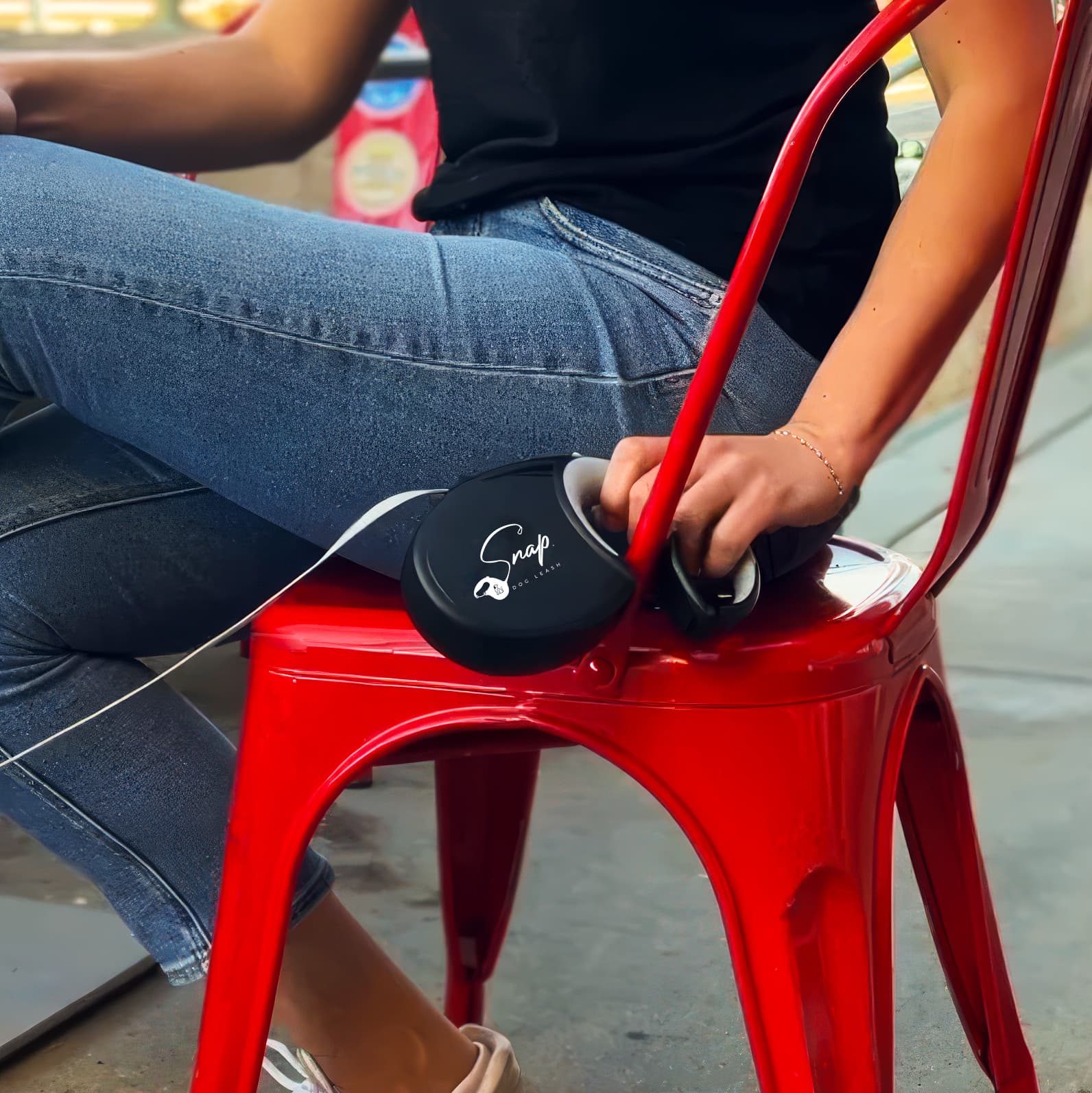 Retractable dog leash that connects to a chair, keeping a dog secured hands-free